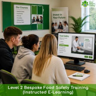 Over-the-shoulder view of three individuals in a classroom studying a digital Food Safety training module on a computer screen, featuring a video on hygiene essentials and handwashing.